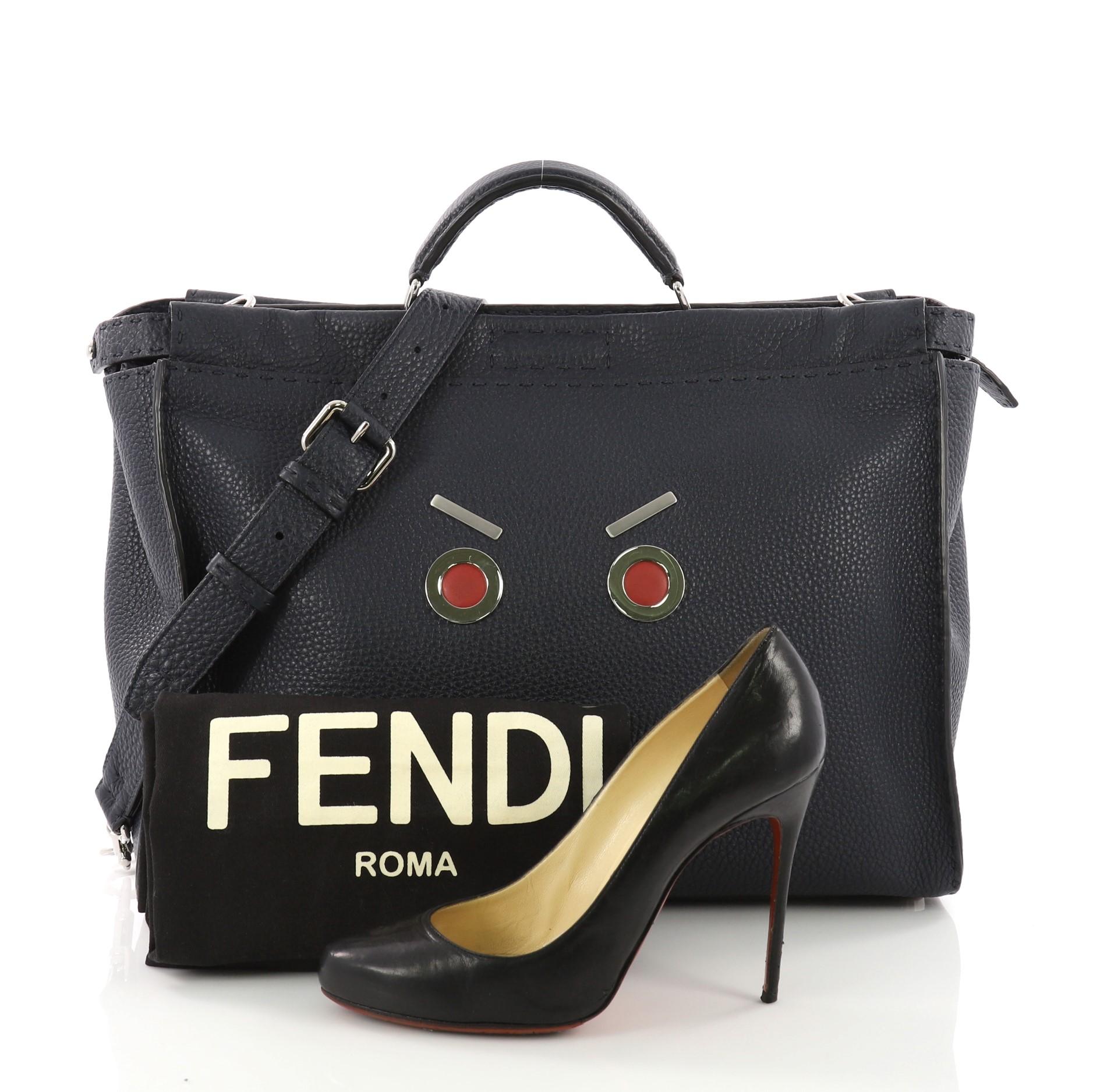 This Fendi Selleria Peekaboo Faces Handbag Leather XL, crafted in blue leather, features single a flat leather top handle, protective base studs and silver-tone hardware. Its turn-lock and zip closures opens to a blue microfiber interior with a zip