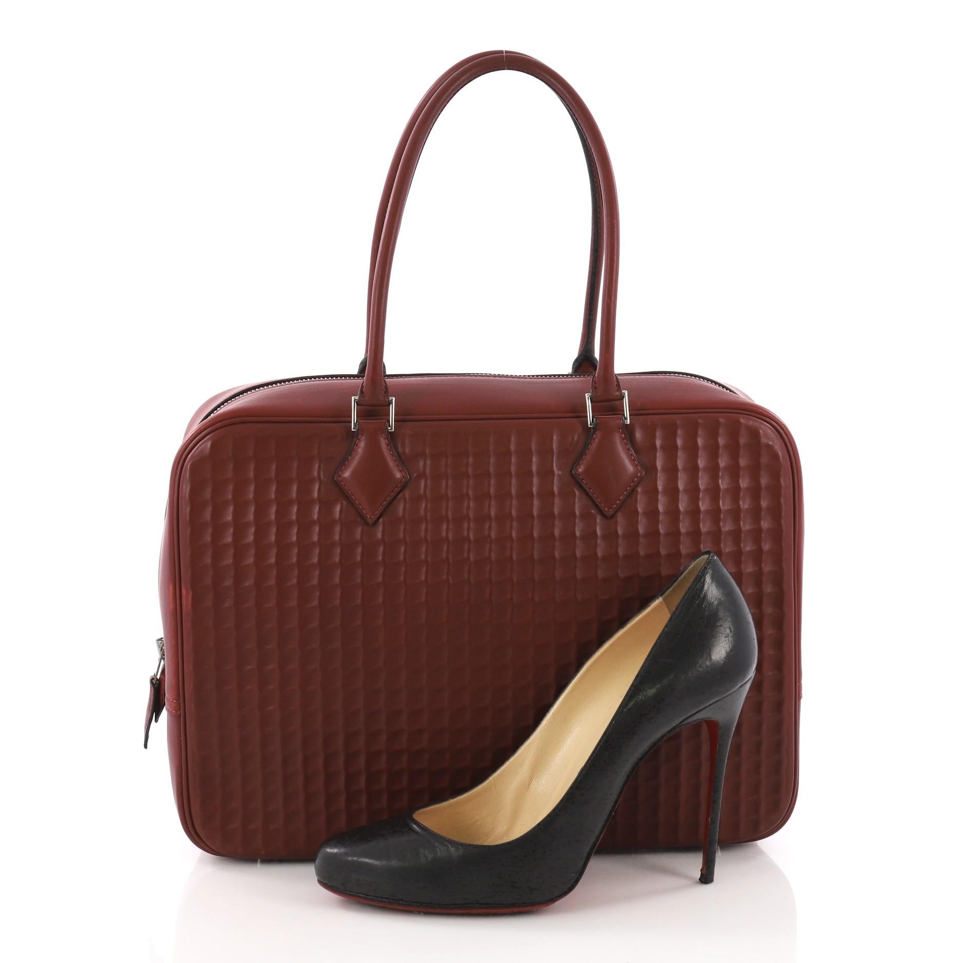 This Hermes Plume Bag Waffle Box Calf 32, crafted in dark red box calf, features dual-rolled leather handles, protective base studs and palladium-tone hardware. Its zip closure opens to a dark red leather interior with a slip pocket. Date stamp