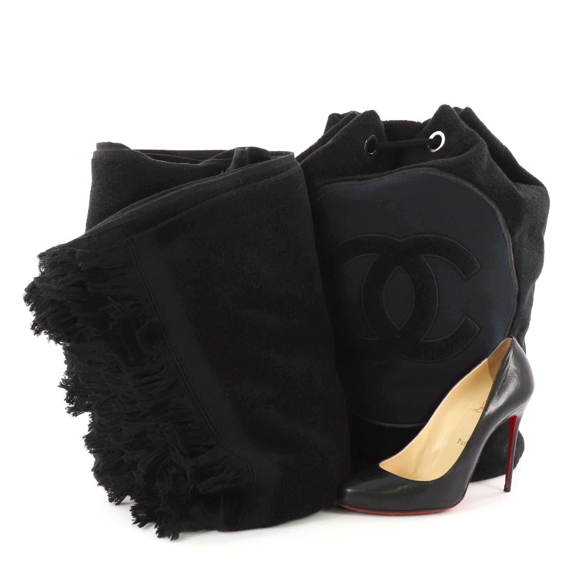 This Chanel CC Drawstring Beach Bag Terry Cloth Large, crafted in black terry cloth, features drawstring closure woven in grommets, shoulder strap and silver-tone hardware. It opens to a black fabric interior. **Note: Shoe photographed is used as a