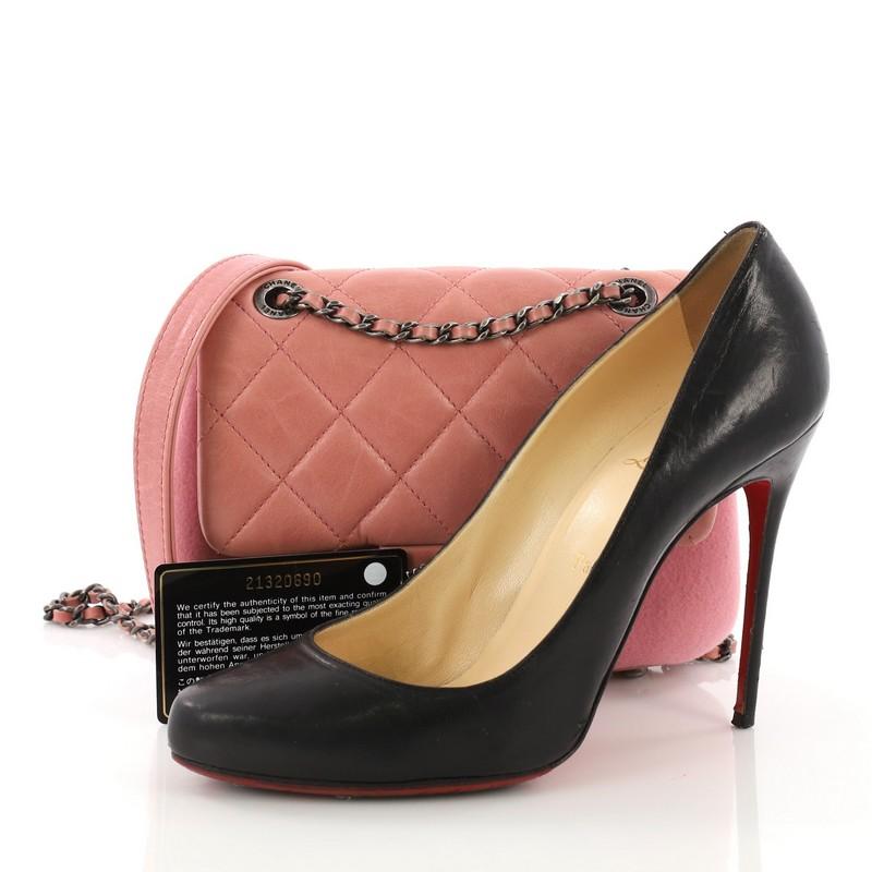 This Chanel Paris-Salzburg Flap Bag Felt and Quilted Calfskin Mini, crafted from pink felt and quilted calfskin leather, features a chain link strap with leather pad and aged silver-toned hardware. Its CC turn-lock closure opens to a burgundy fabric
