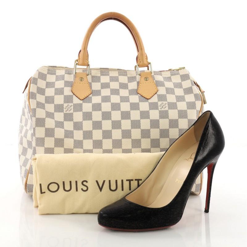 This Louis Vuitton Speedy Handbag Damier 30, crafted in damier azur coated canvas, features dual rolled handles, vachetta leather trims and gold-tone hardware. Its top zip closure opens to a beige fabric interior with slip pocket. Authenticity code