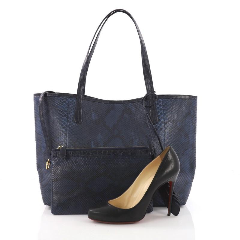 This Nancy Gonzalez Erica Tote Python with Crocodile Large, crafted in genuine dark blue python with crocodile skin trims, features dual crocodile strap and gold-tone hardware. It opens to a tan fabric interior. **Note: Shoe photographed is used as