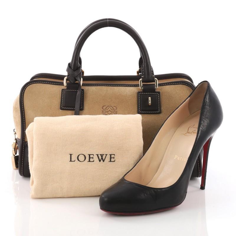This Loewe Amazona Bag Suede 28, crafted from tan suede, features dual rolled leather handles, embossed logo at front, and gold-tone hardware. Its zip closure opens to a tan leather interior with snap pocket. **Note: Shoe photographed is used as a