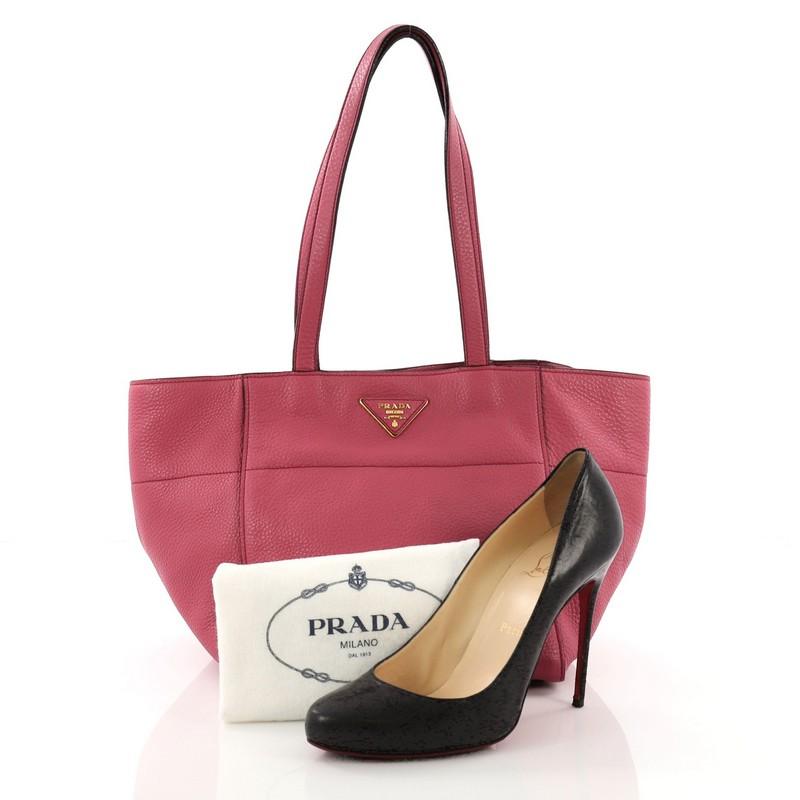 This Prada Open Tote Vitello Daino Small, crafted from pink vitello daino leather, features dual-flat leather handles and gold-tone hardware. Its hidden magnetic snap button closure opens to a beige fabric interior with side zip and slip pockets.