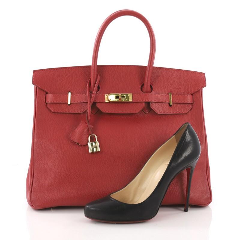 This Hermes Birkin Handbag Rouge Vif Ardennes with Palladium Hardware 35, crafted in Rouge Vif ardennes leather, features dual rolled handles, front flap and palladium-tone hardware. Its turn-lock closure opens to a red leather interior with slip