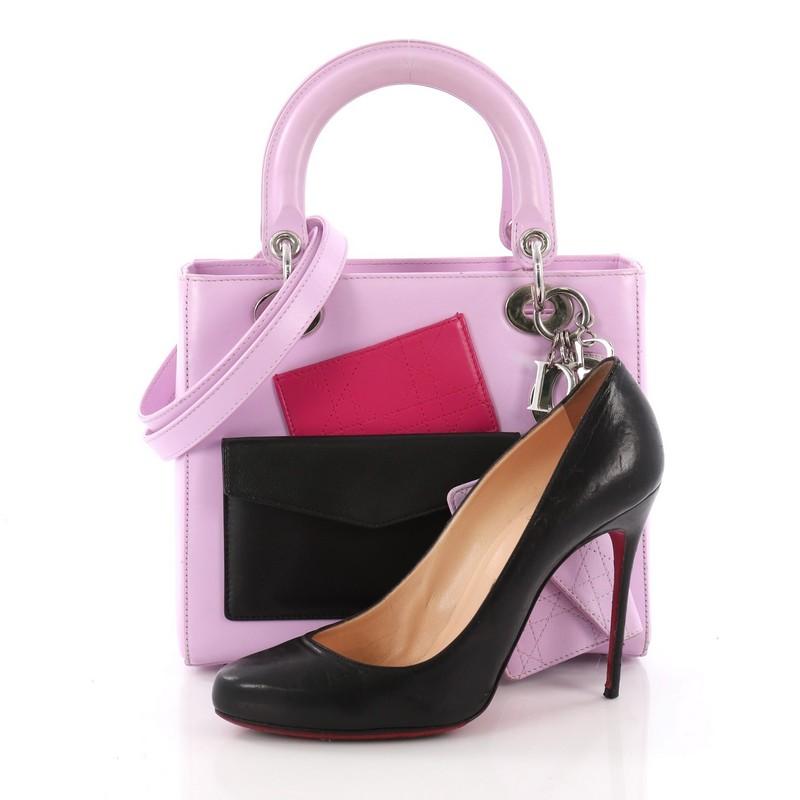 This Christian Dior Lady Dior Pockets Handbag Leather Medium, crafted in purple leather, features smooth short dual handles with sleek Dior charms, two front pocket, and silver-tone hardware. The bag's top zip closure opens to a purple leather