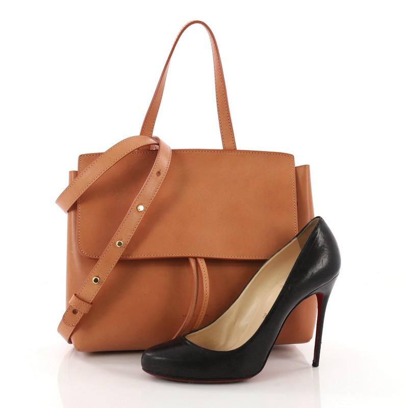 This Mansur Gavriel Lady Bag Leather Mini, crafted in brown leather, features a top flat leather handle and gold-tone hardware. Its hidden drawstring and magnetic closure opens to a pink leather interior with zip and slip pockets. **Note: Shoe