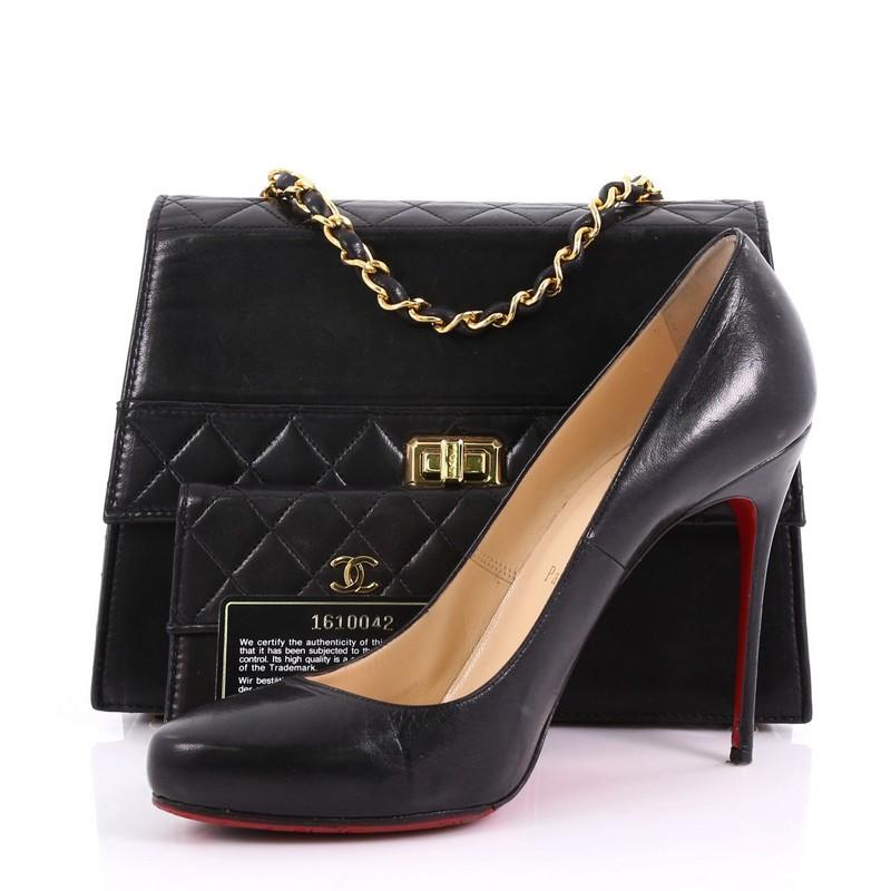 This Chanel Vintage Trapezoid CC Flap Bag Leather Small, crafted in black leather, features a woven in leather chain link strap, an exterior back slip pocket, and gold-tone hardware. Its CC turn-lock closure opens to a red leather interior with snap