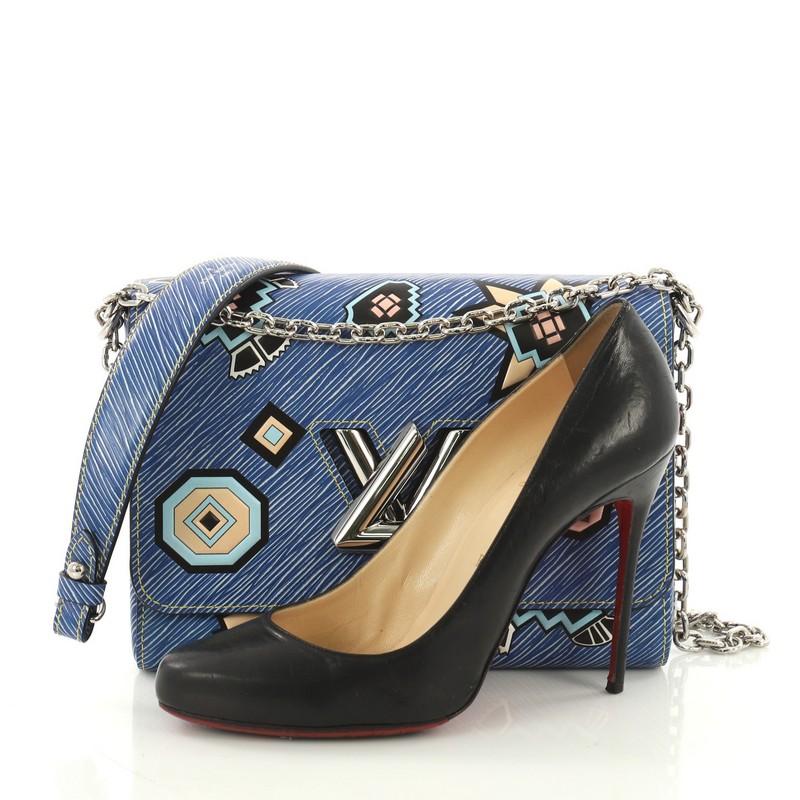 This Louis Vuitton Twist Handbag Limited Edition Azteque Epi Leather MM, crafted from blue azteque epi leather, features long chain strap with leather pad and silver-tone hardware. Its flap with twist-lock closure opens to a grey microfiber interior