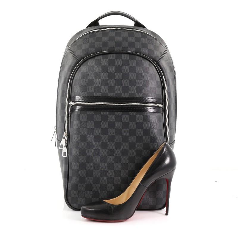 This Louis Vuitton Michael NM Backpack Damier Graphite, crafted in damier graphite coated canvas, features a short flat leather top handle, two canvas padded backpack straps, two exterior front zip pockets and silver-tone hardware. Its two-way zip