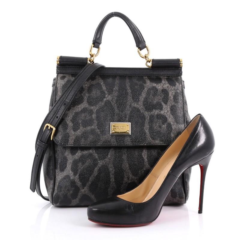 This Dolce & Gabbana Miss Sicily Handbag Leopard Print Leather North South, crafted in black and gray leopard print leather, features leather top handle, framed top flap, and gold-tone hardware. Its magnetic snap closure opens to a black fabric