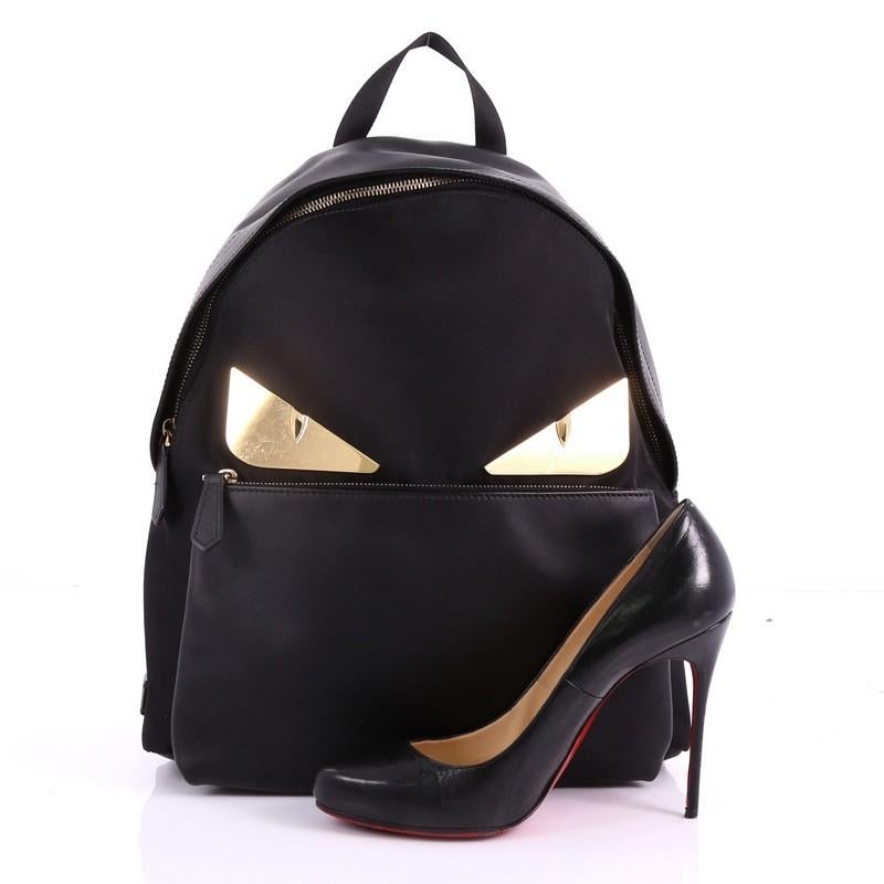 This Fendi Monster Backpack Nylon with Leather Large, crafted from black leather and nylon, features Fendi's popular monster design, adjustable shoulder straps, exterior front zip pocket, and gold-tone hardware. Its zip closure opens to a black