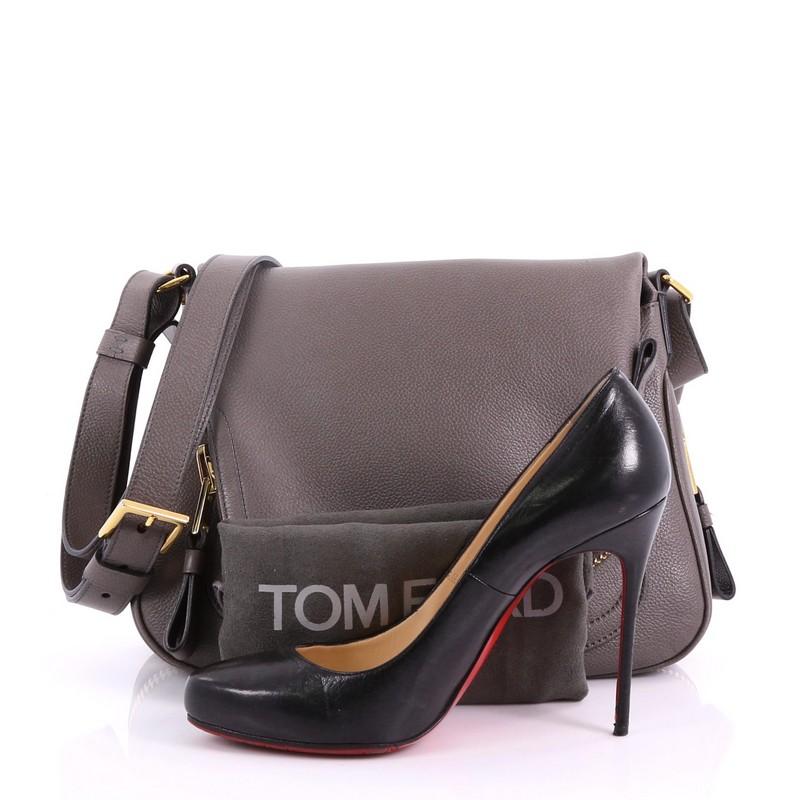 This Tom Ford Jennifer Crossbody Bag Leather Medium, crafted in taupe leather, features an adjustable crossbody strap, zip-top fold-over flap, and gold-toned hardware. Its zip closure opens to a black microfiber interior with side zip pocket.