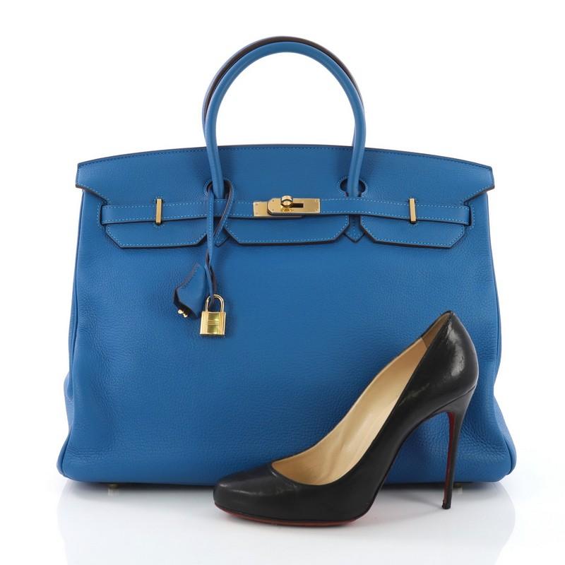 This Hermes Birkin Handbag Mykonos Clemence with Gold Hardware 40, crafted in mykonos blue clemence leather, features dual rolled top handles, frontal flap, and gold-tone hardware. Its turn-lock closure opens to a blue leather interior with side zip