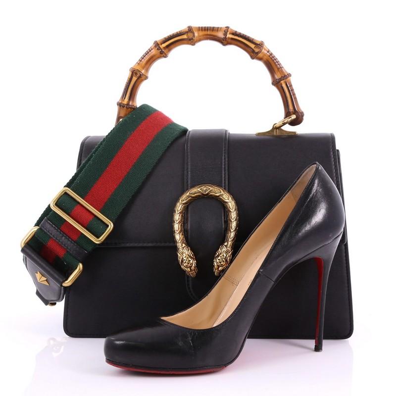 This Gucci Dionysus Bamboo Top Handle Bag Leather Medium, crafted from black leather, features a bamboo top handle, textured tiger head spur detail, and aged gold-tone hardware. Its hidden push-pin closure opens to a beige fabric interior divided