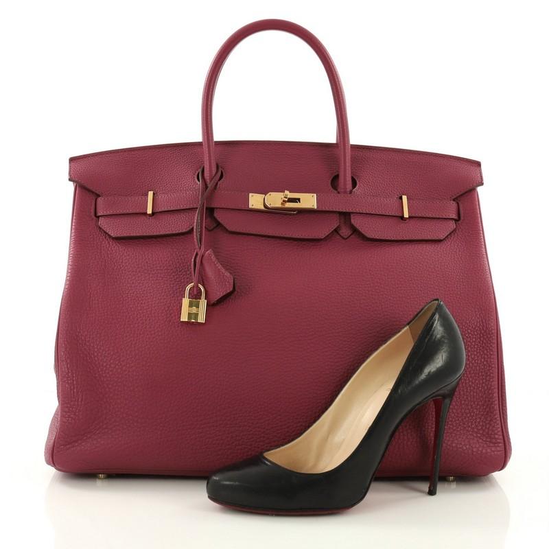 This Hermes Birkin Handbag Rubis Togo With Gold Hardware 40, crafted from Rubis togo leather, features dual rolled top handles, frontal flap, and gold-tone hardware. Its turn-lock closure opens to a rubis pink leather interior with side zip and slip