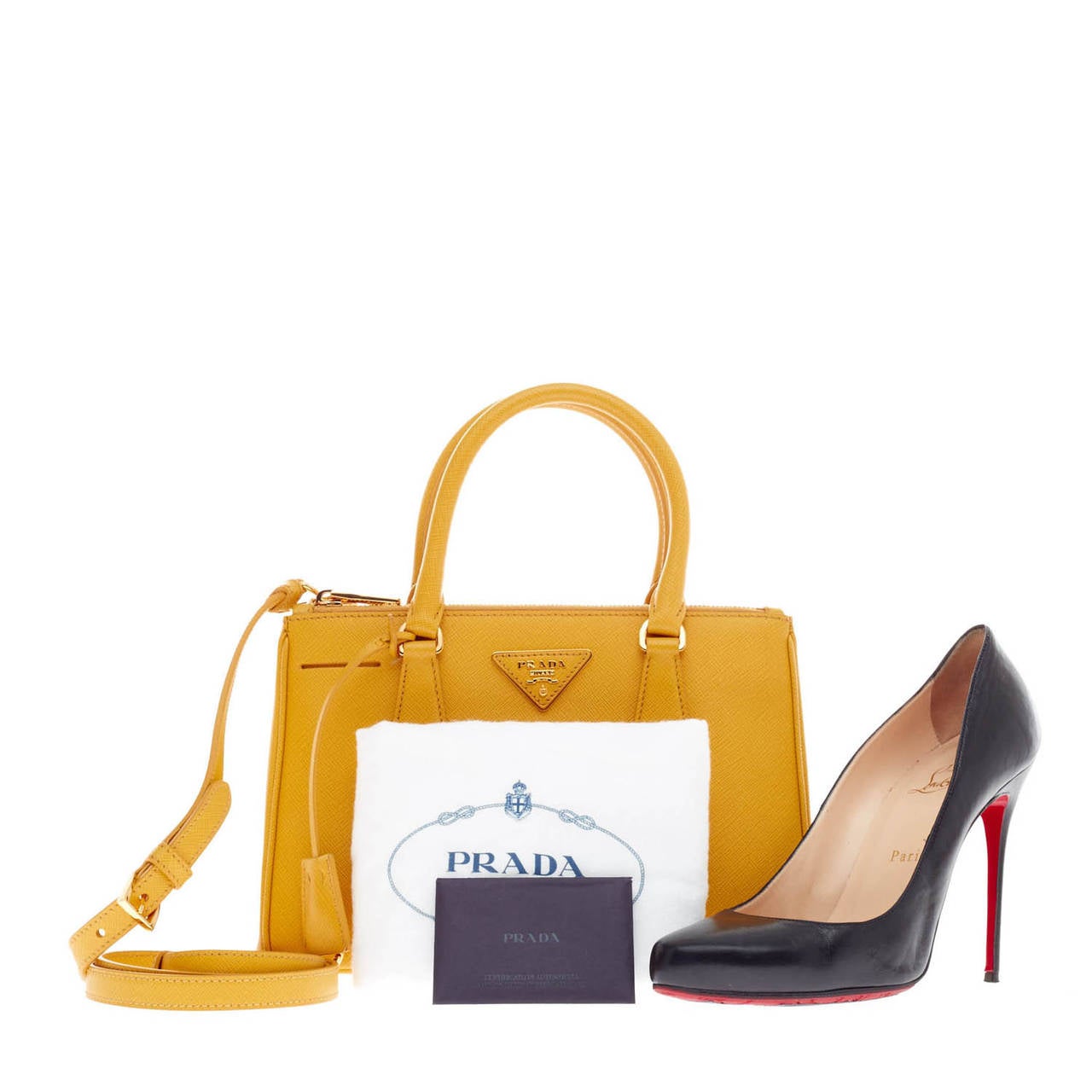 This authentic Prada Saffiano Two Zip Lux Tote Mini in Mimosa is the perfect petite bag to complete any spring outfit. It is an elegant and chic statement piece that can be handheld or worn on the shoulder with its detachable adjustable shoulder