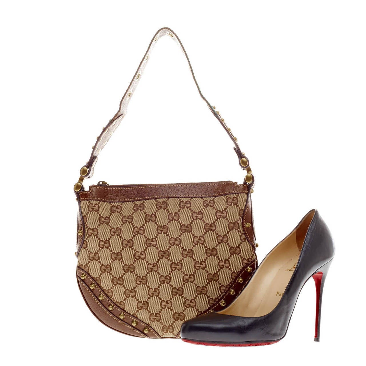 This authentic Gucci Pelham Hobo Studded Canvas in Small is the perfect, compact flat hobo to carry by your side. This western-inspired saddle bag is constructed with the brand's classic GG monogram print, and accented with brown leather trims and