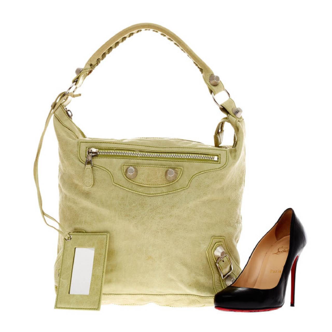 This authentic Balenciaga Day Giant Studs in soft supple apple-green distressed leather is a go-to essential that fits everyday essentials. This spacious hobo is accented with an intertwined braided leather top handle, giant silver hardware and stud