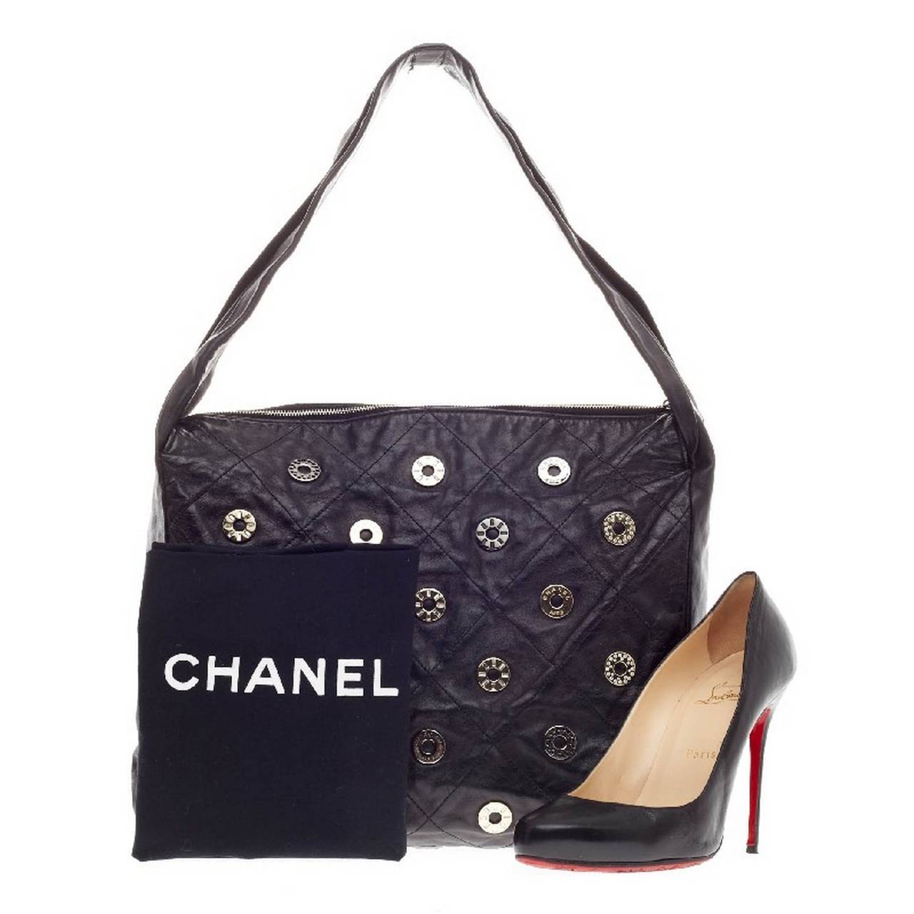 This authentic Chanel Snaps Zip Hobo Leather is a great everyday accessory for the on-the-go woman. Crafted from soft black diamond quilted leather, this no-fuss hobo is designed with decorative Chanel snap studs on its exterior and silver-tone