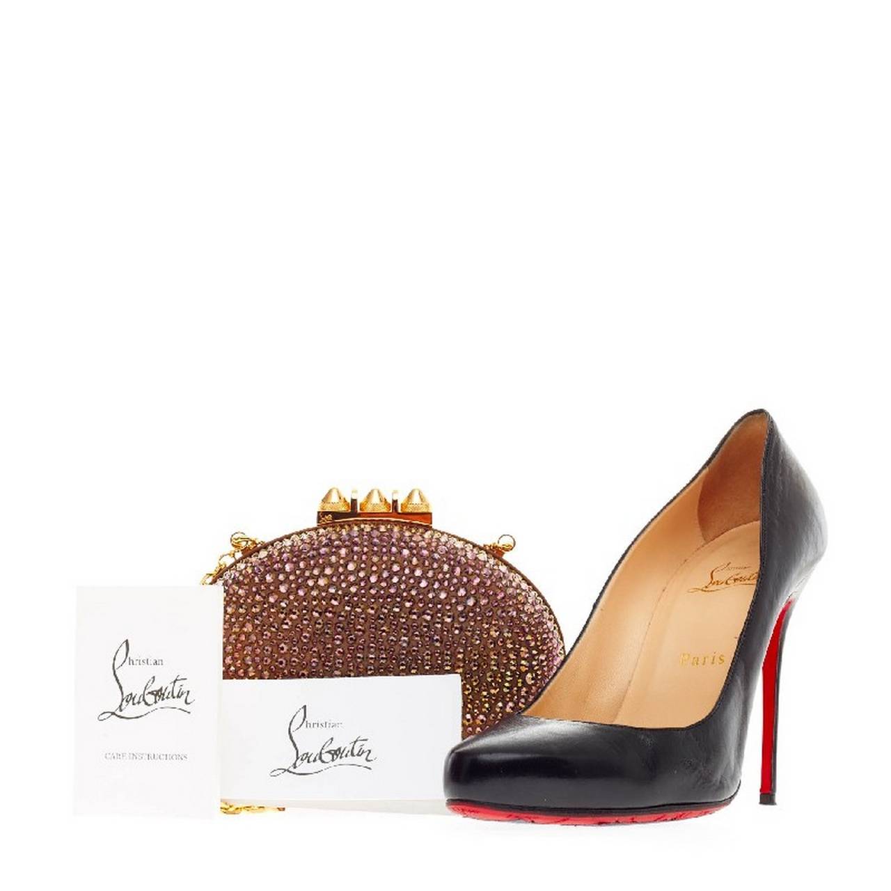 This authentic Christian Louboutin Mina Clutch Strass is a must-have accessory for any formal or evening event. Decorated in luminescent dark metallic purple and gold shade crystal embellishment, this eye-catching rounded clutch features