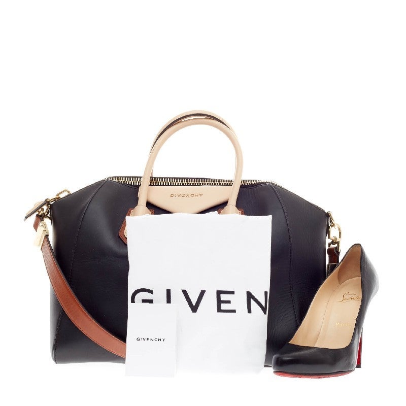 This authentic Givenchy Antigona Bag Leather Tricolor Medium is one of the season's hottest bags. Crafted from smooth black leather with contrasting beige leather handles and tan straps, this structured tricolor handle bag is designed with the