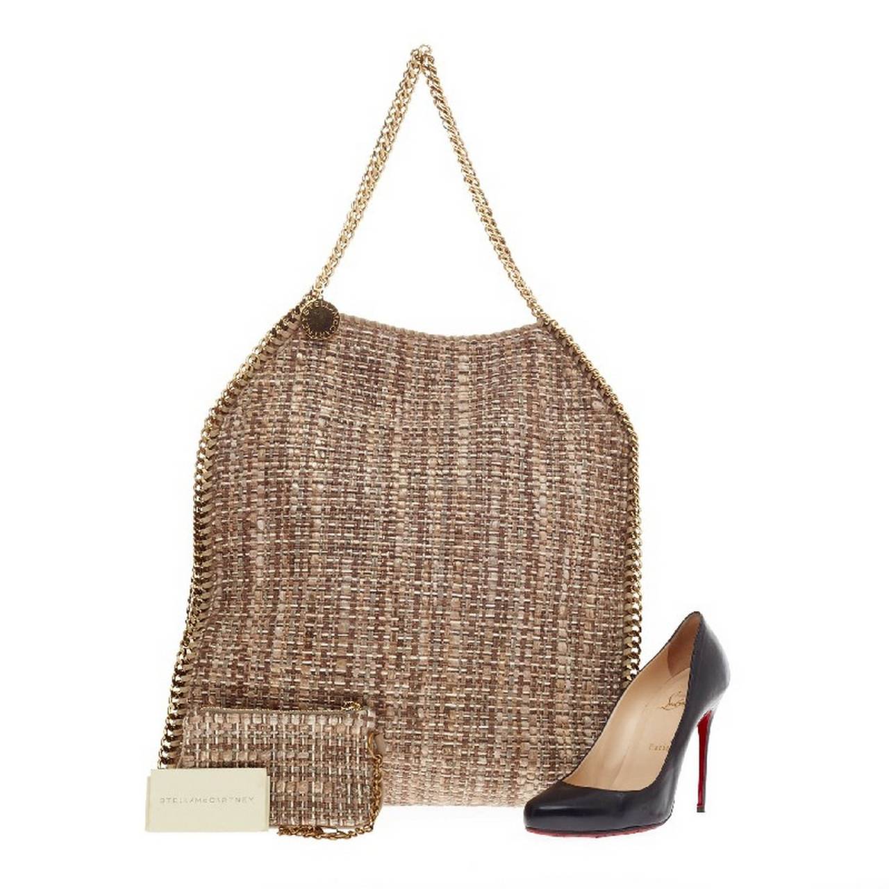 This authentic Stella McCartney Falabella Tote Boucle in size Large is perfect for casual day-to-day excursions. Crafted in natural hues boucle tweed, this soft tote features tonal brown and beige shades, gold metal chain link strap and trimmings,