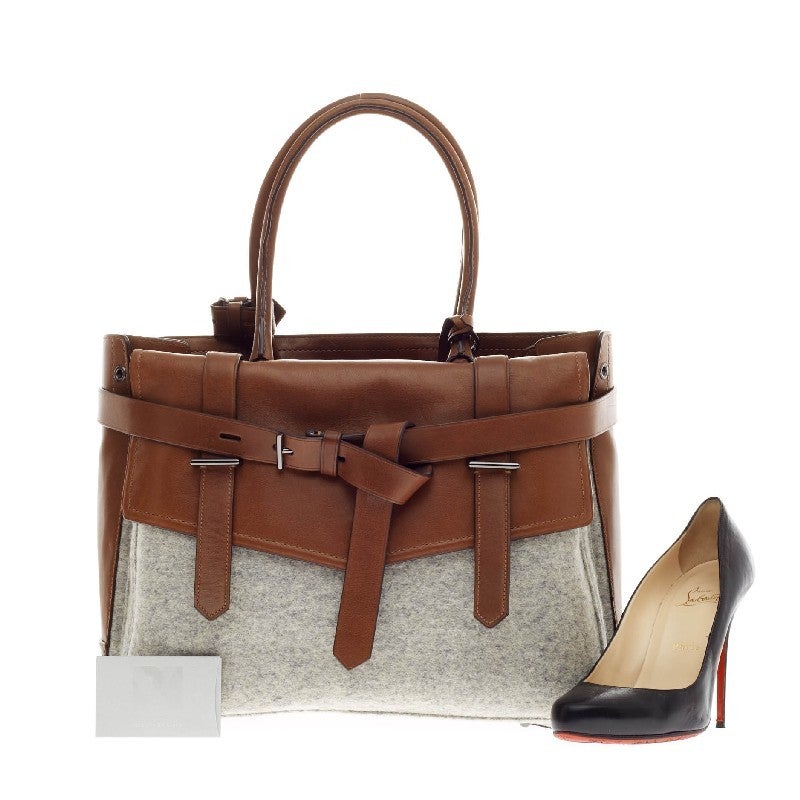 This authentic Reed Krakoff Boxer Tote Wool and Leather Medium is a versatile structured bag that complements both dressy and casual looks perfect for the modern woman. Constructed in brown leather and heather grey wool, this functional tote