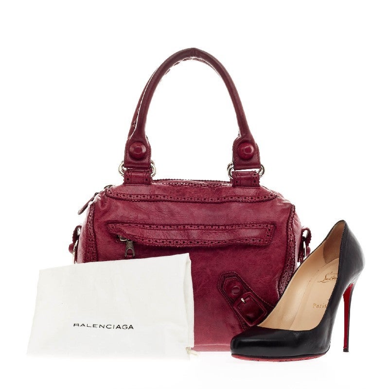 This authentic Balenciaga Metro Giant Studs Brogues Leather in Medium is great for fashionistas on-the-go. Crafted from raspberry distressed leather, this boxy petite bag features perforated trim details, dual leather straps, silver-tone hardware