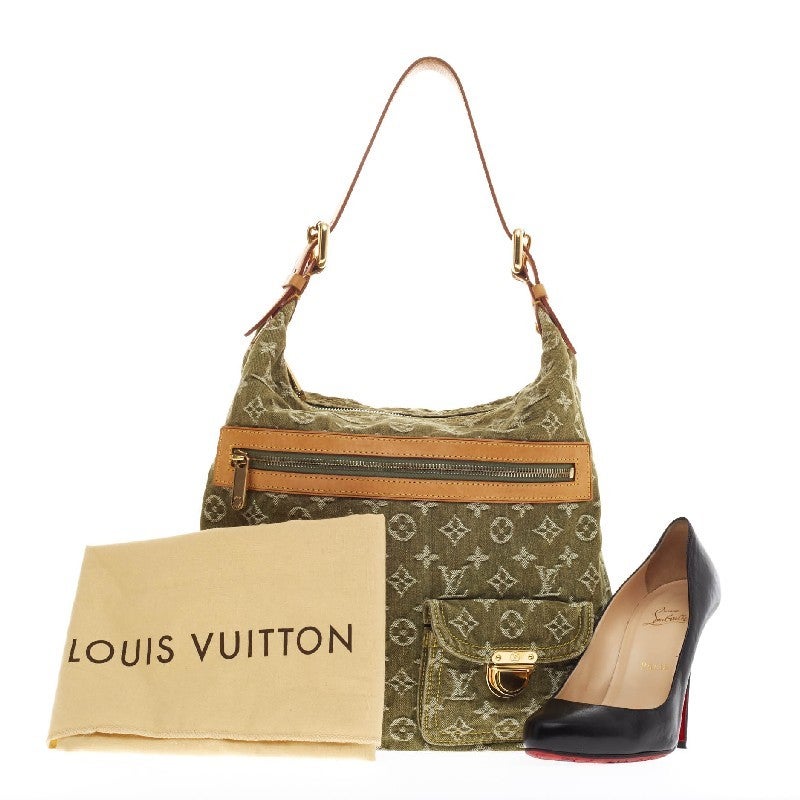 This authentic Louis Vuitton Baggy Denim GM is a fresh twist on an iconic design that will stylishly complement a casual look. Crafted from lichen green monogram print in washed denim fabric, this bag features vachetta leather trim, yellow contrast