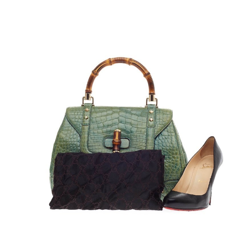 This authentic Gucci Bamboo Top Handle Alligator Large is an ode the brand's iconic timeless design showcased in the most luxurious of ways. Crafted from genuine vivid green alligator, this beautiful exotic bag features Gucci's signature single