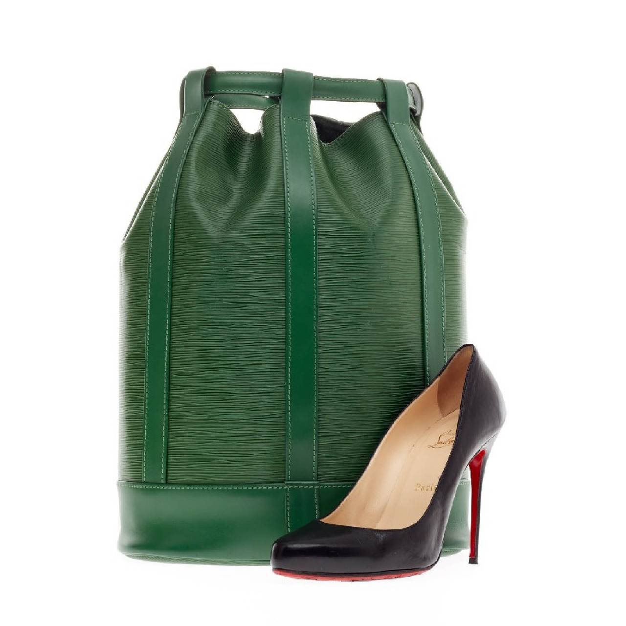 This authentic Louis Vuitton Randonnée Epi Leather PM in vivid green shade combines the functionality of an everyday carry-all and chicness in style all in one. The unique backpack opens to a spacious interior  that closes with the pull of the