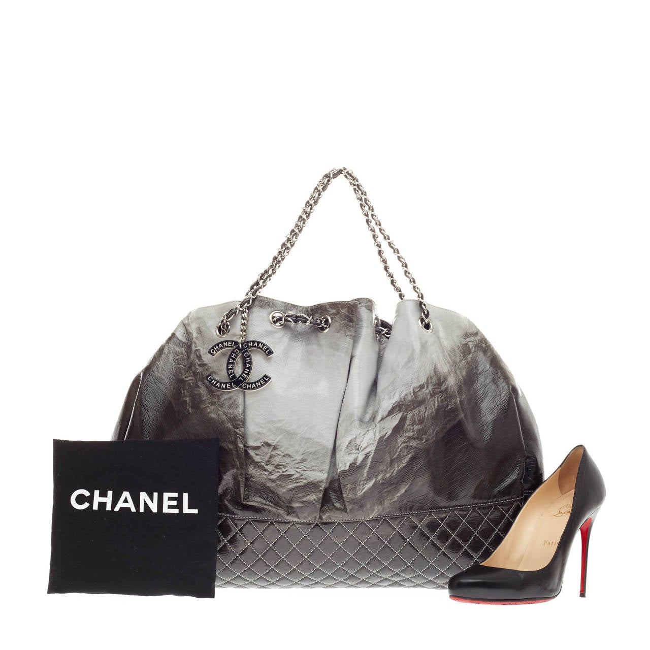 This authentic Chanel Melrose Degrade Cabas Tote Patent is perfect for the on-the-go fashionista. Crafted from grey and black patent leather, this oversized stand-out tote features quilted diamond base, woven-in leather chain strap that cinches or