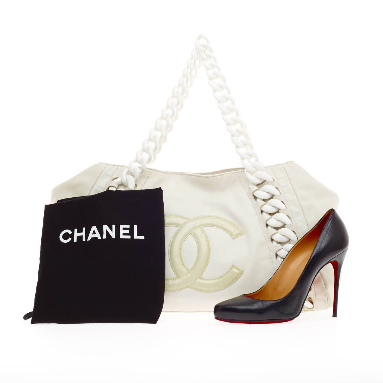 This authentic Chanel Resin Modern Chain Tote Leather showcases a playful, sporty style perfect for avid Chanel lovers. Constructed from sumptuous white leather, this oversized tote features large resin chain link straps and details, patent