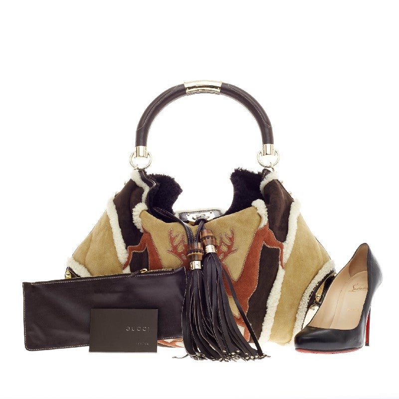 This authentic Gucci Indy Hobo Suede and Merinos Sheepskin showcase a woodland-inspired twist to the classic Gucci Indy bag in beautiful autumnal colors. This eye-catching bag features a reindeer print design with bamboo tassel accents, structured
