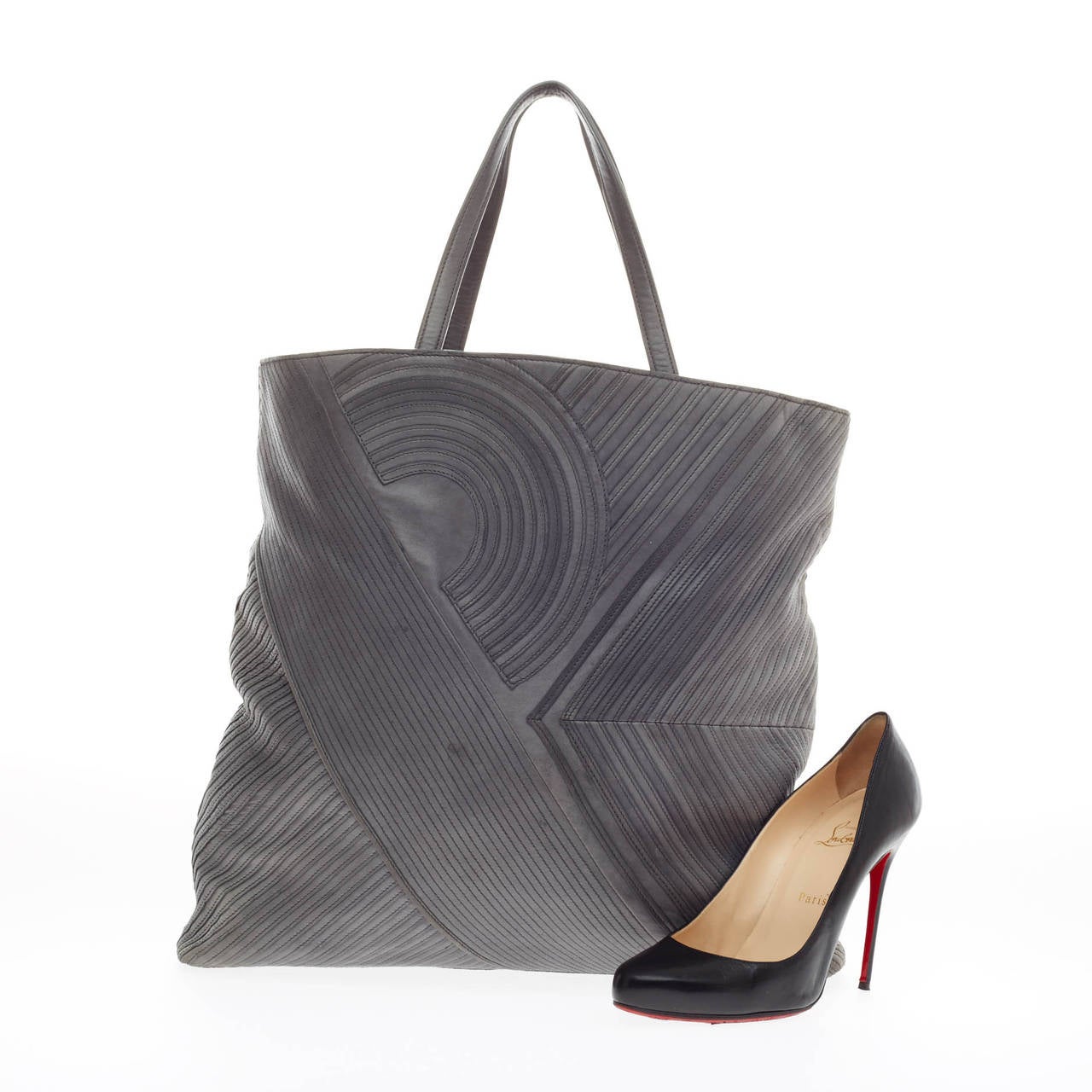 This authentic Reed Krakoff Stitched Tote Leather complements both dressy and casual looks perfect for the modern woman. Crafted from soft gray leather with flat top handles, this roomy no-fuss tote features diagonal trims and pleating throughout