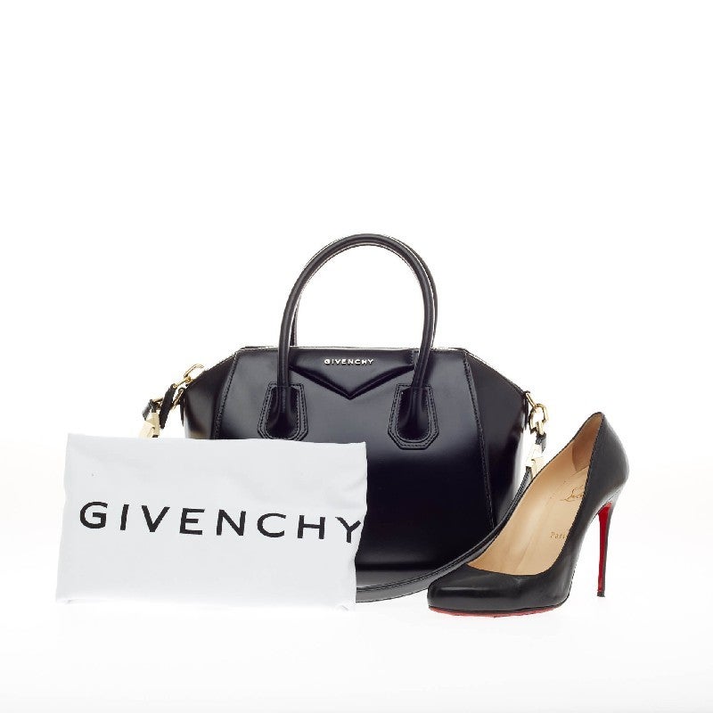 This authentic Givenchy Antigona Bag Leather Small is one of the season's hottest bags. Crafted from smooth black leather and featuring gold-tone hardware, this structured handle bag is designed with the brand's signature envelope flap detail with