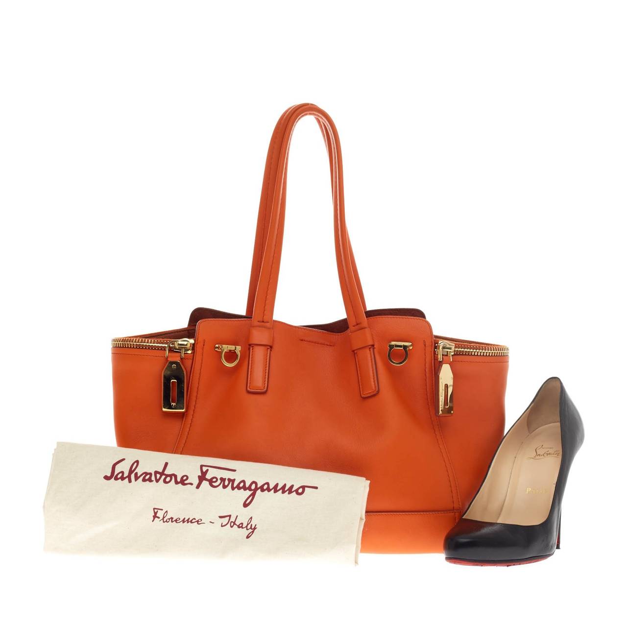 This authentic Salvatore Ferragamo Verve Tote Leather Medium is a vibrant and glamorous tote perfect for traveling in style or for a weekend getaway. Crafted in vibrant orange soft leather, this elegant bag features dual rolled handles, two side