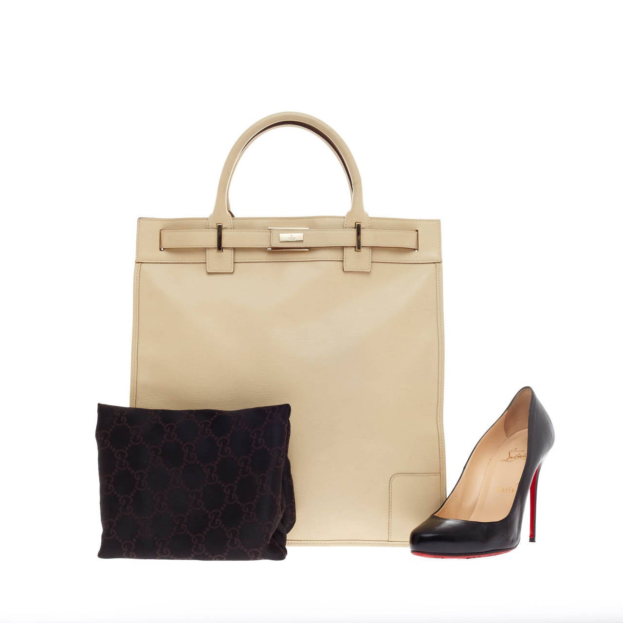 This authentic Gucci Vertical Tote Leather is the perfect neutral tote for daily use. Crafted in creme leather, this tote features a simple, structured sillhouette, dual-rolled top handles and silver-tone hardware accents. Its press-lock closure