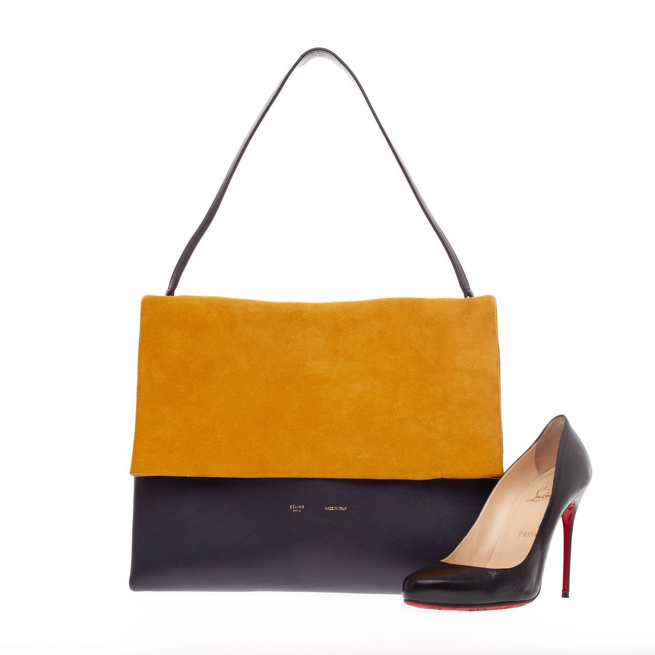 This authentic Celine All Soft Tote Suede showcases a neutral and understated look perfect for the modern woman. Crafted in golden yellow with an olive suede under flap with navy blue leather base, this tote features silver-tone hardware accents and