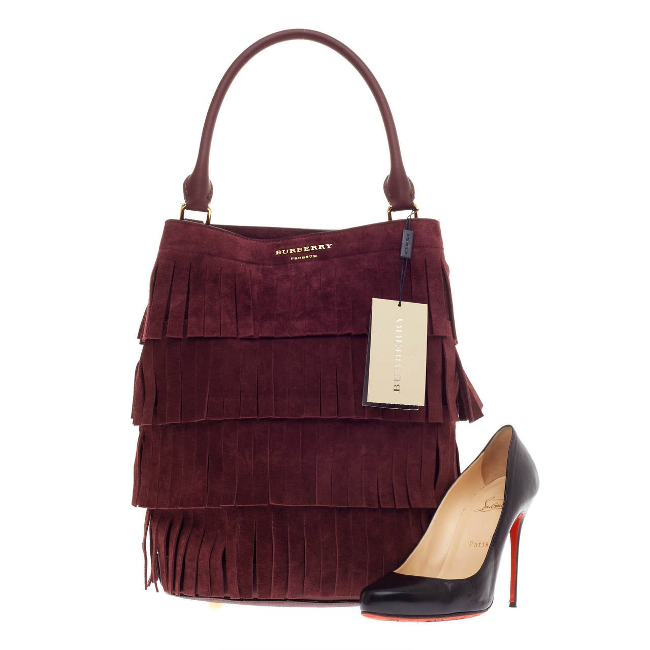 This authentic Burberry Tiered Fringe Bucket Bag Suede is chic design with 70's inspired flair which can be worn fashionably. Crafted in soft maroon suede in a tiered fringe design, this bucket bag features a single looped leather handle, sturdy