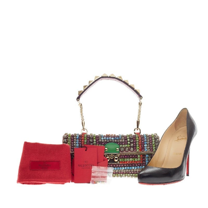 This authentic Valentino Rockstud Shoulder Bag Crystal Encrusted showcases a vibrant style perfect for night outs. Constructed in taupe and red leather with embellished multicolored crystals, this eye-catching and unique flat clutch is accented with