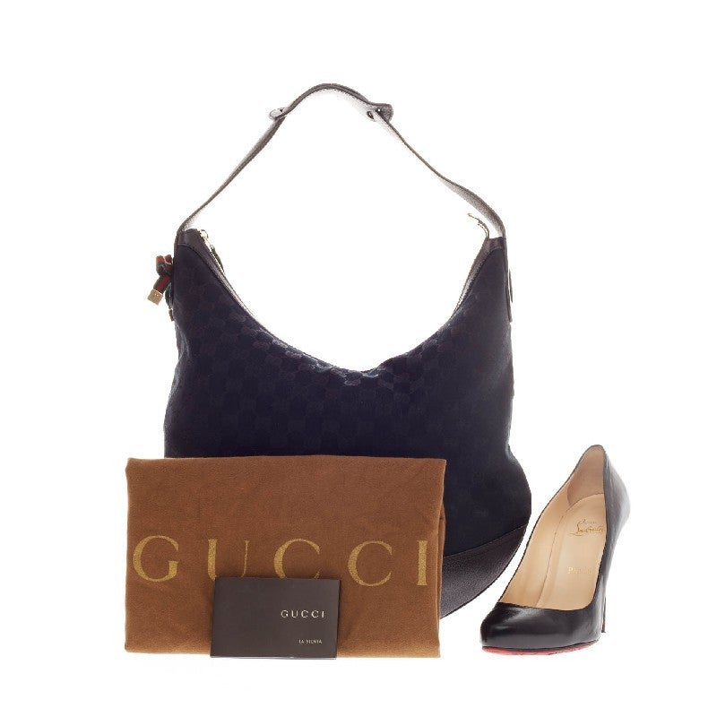 This authentic Gucci Princy Hobo GG Canvas Large is an essential everyday bag that mixes understated style and fucntionality. Constructed in black GG monogram canvas with red and green side ribbon accents, this hobo features leather trim details