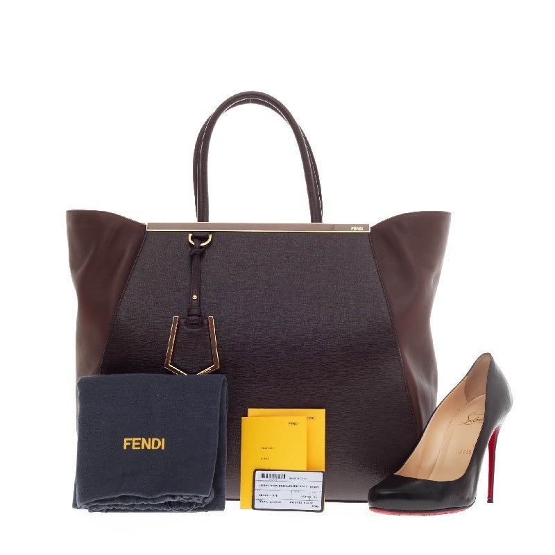 This authentic Fendi 2Jours Leather Large is impeccably stylish. Crafted in chocolate brown cross-grain leather with smooth side wings, this popular tote is accented with a shining top bar that dons the Fendi brand name and protective gold base