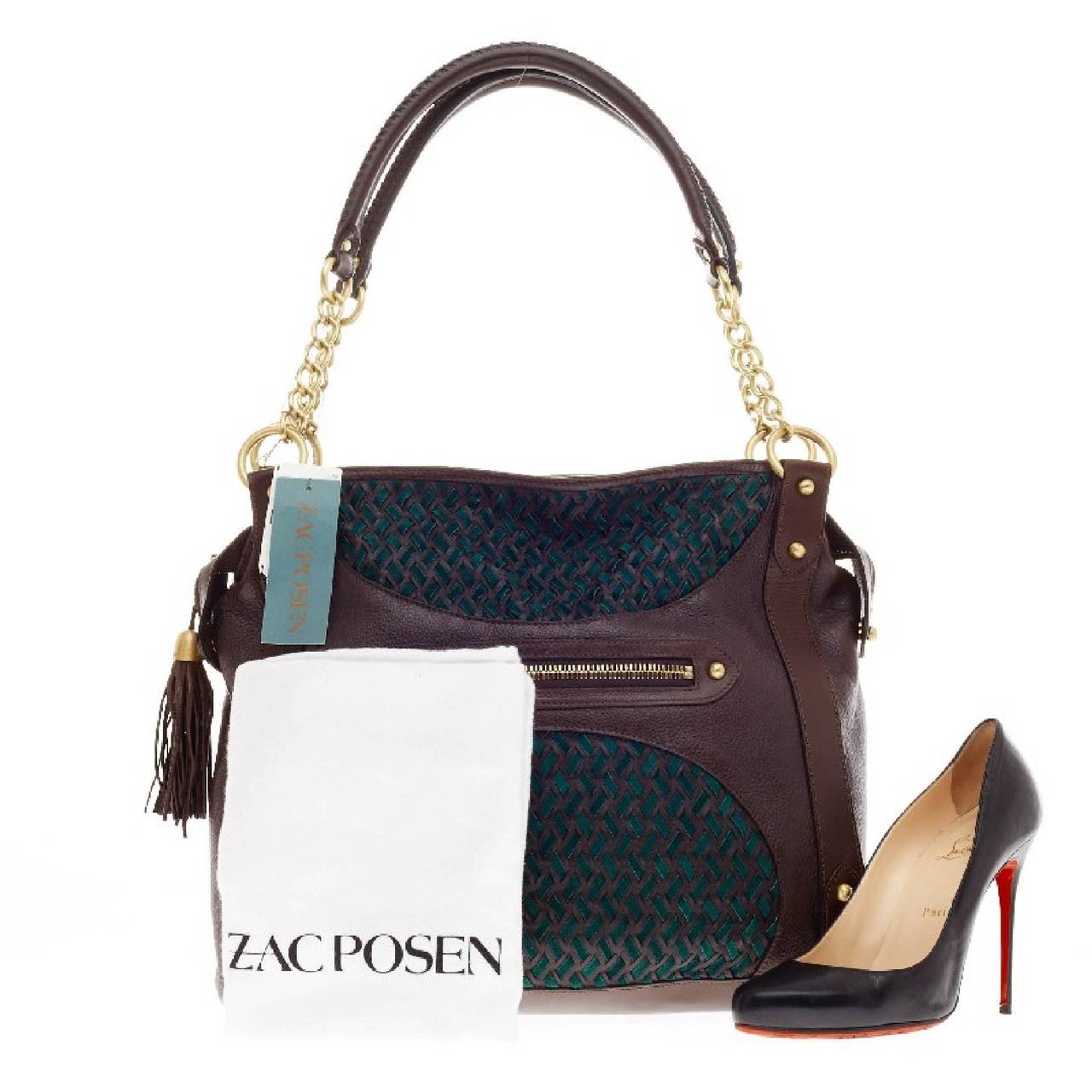 This authentic Zac Posen Lauren Tote Woven Leather will add style to any daily casual outfit. Constructed in brown leather with elegant woven green suede details, this beautiful tote features dual gold chain straps with tassel charms and leather