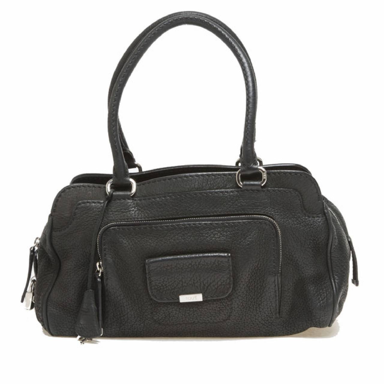 This authentic Tod's Top Handle Front Pocket bag is constructed in soft black pebbled leather. The bag features various pockets on the exterior, a half-zip and snap button closure pocket on the front flap. An easy, roomy satchel with dual rolled