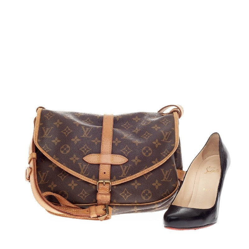 This authentic Louis Vuitton Saumur Monogram Canvas MM features double saddle compartments with side buckle leather closures and brass closures on the frontal flaps. Its long adjustable straps convert this into a care-free crossbody bag ideal for