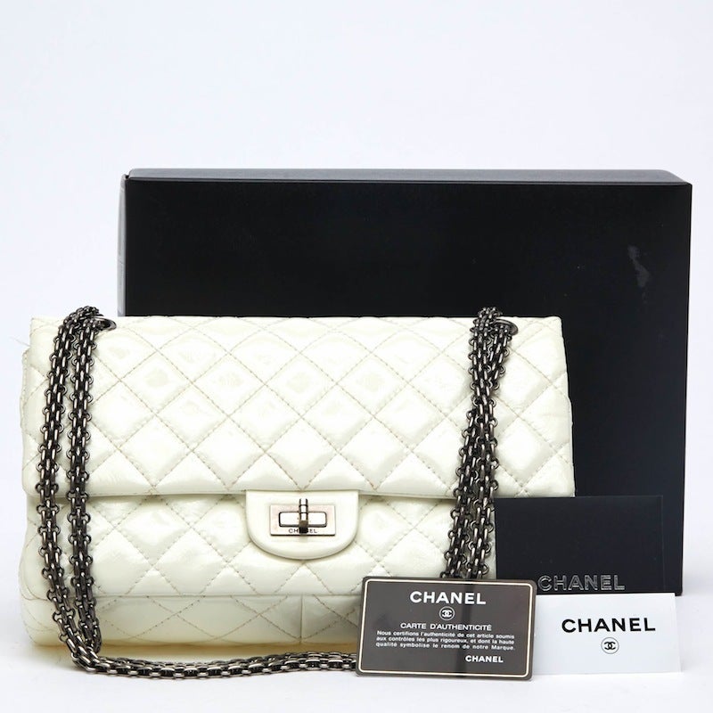 This timeless Chanel Patent Leather Reissue 2.55 in size 226 is eye-catching and understated. It is constructed with Chanel's signature diamond quilted leather and accented with silver 