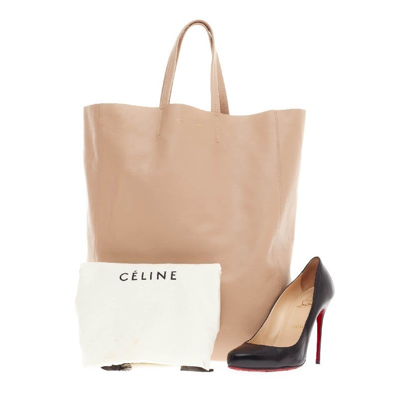 This authentic Celine Vertical Cabas Tote Leather Large is a perfect everyday accessory for the woman on-the-go. Crafted in light beige leather, this minimalist bag features slim handles and gold stamped brand name. Its roomy suede-lined interior