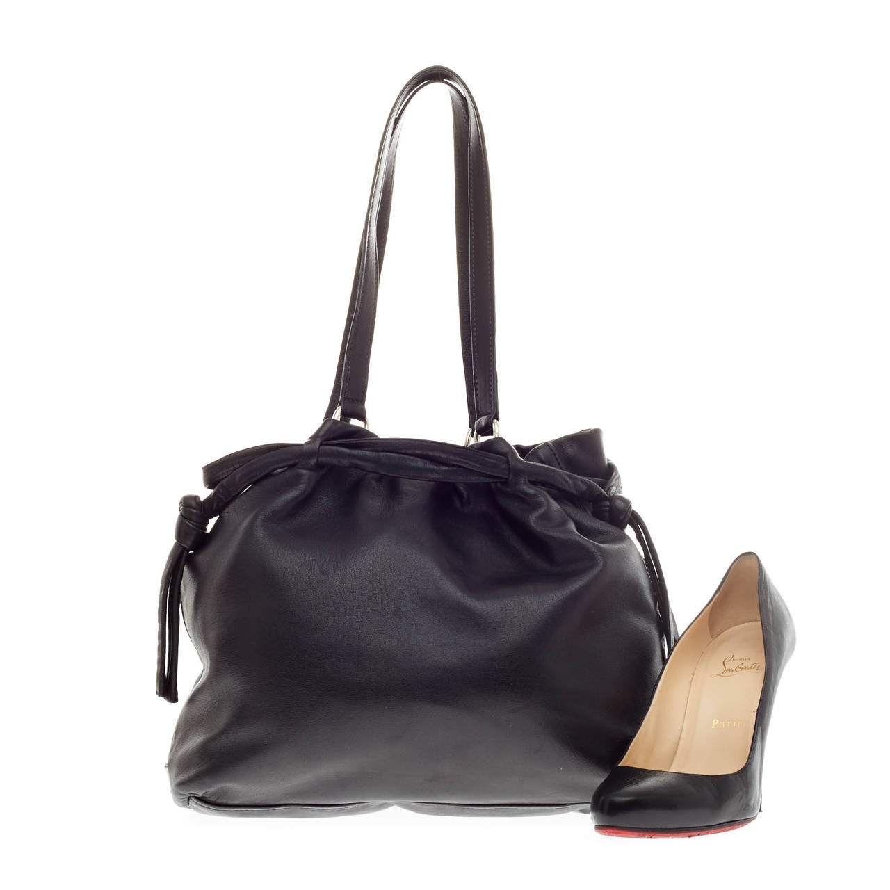 This authentic Prada Tie Side Top Tote Leather is a perfect companion for daily excursions. Crafted in soft black leather, this no-fuss tote bag features tall dual shoulder straps, tie side top detailing, side Prada triangle logo and silver-tone
